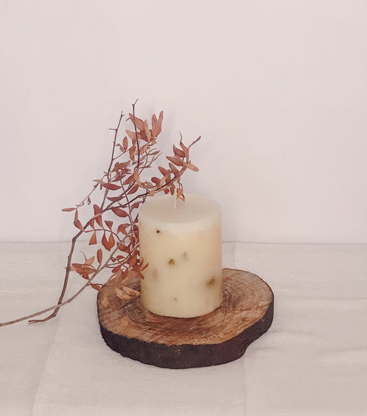 Hero Aromatic Candle displayed on a rustic wood slice with dried leaves, evoking romance and tranquility.